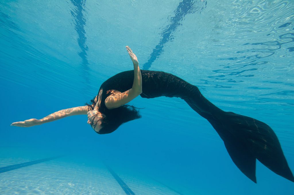 woman with mermaid fin in pool