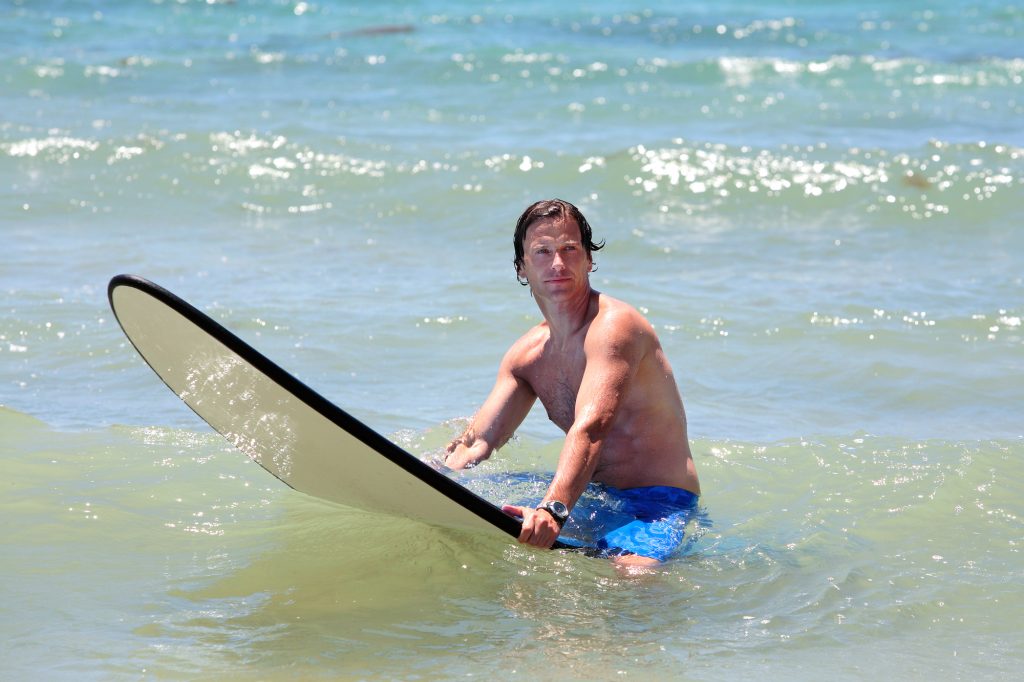 surfer with watch looking towards the beach