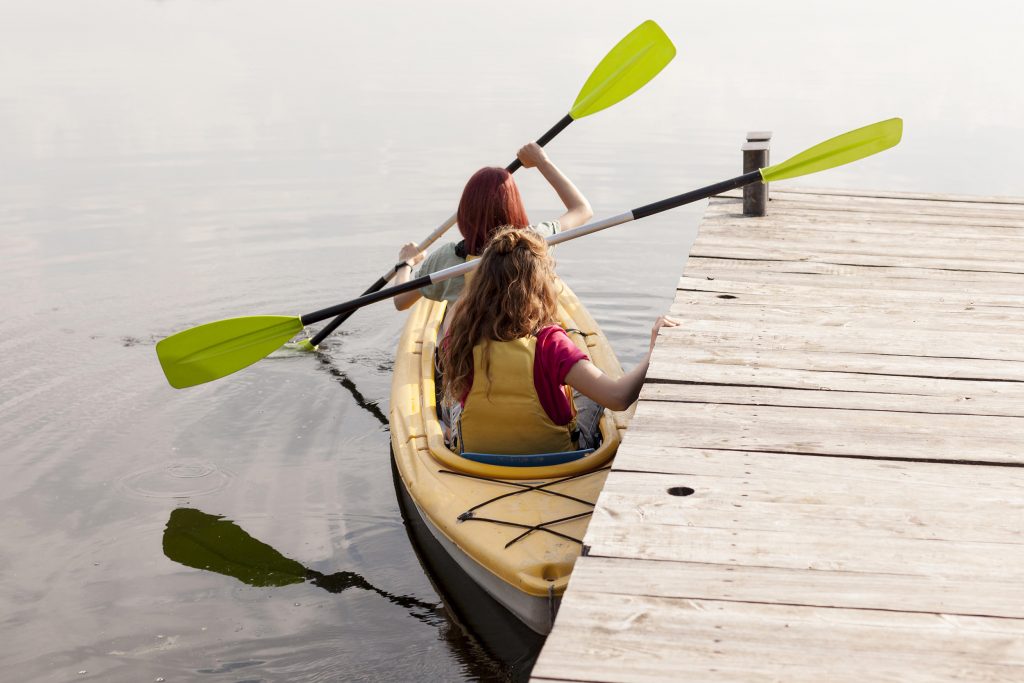 women in kayak near dock