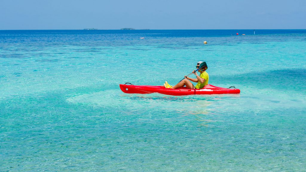 man in paradise water on sit on top kayak