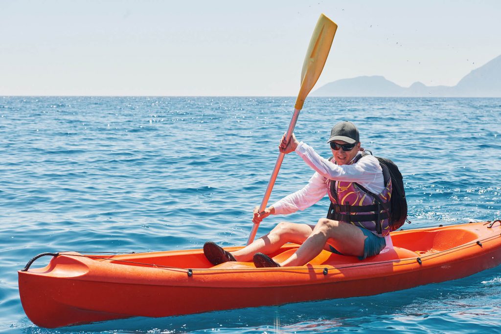 man kayaking on sunny day