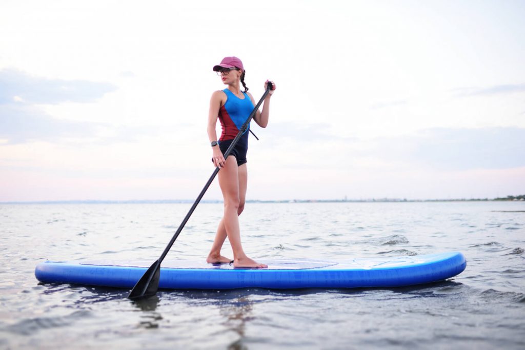 girl standing on an inflatable paddle board